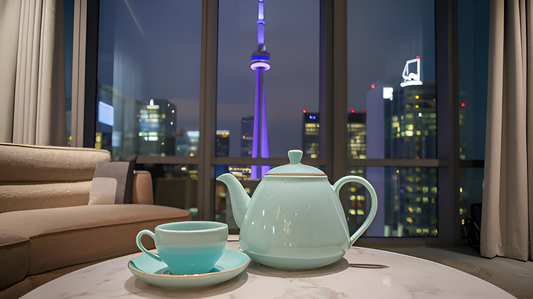 Tiffany blue teacup and pot in a cozy living room with a panoramic night view of the CN Tower